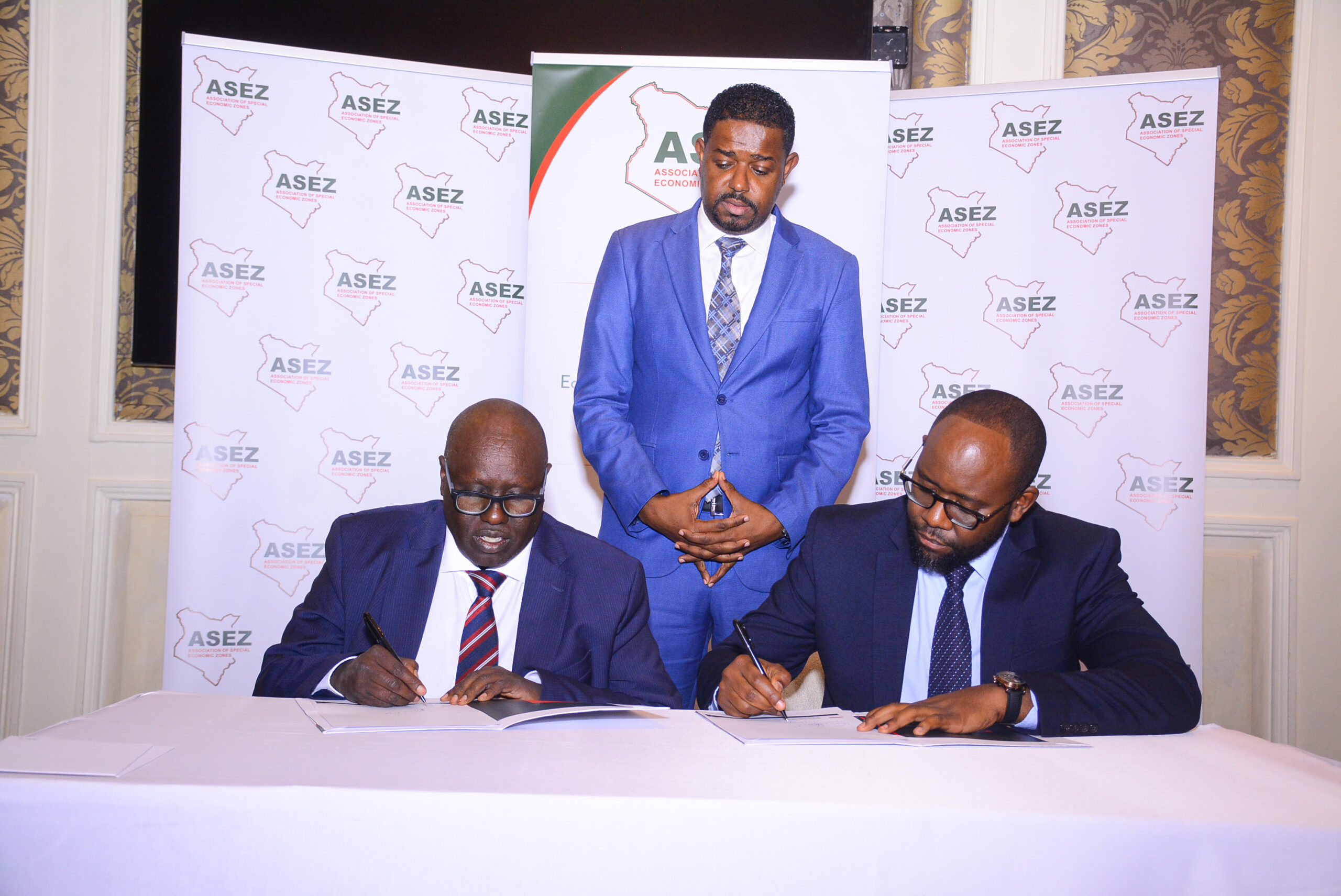 Hon. Abubakar Hassan Abubakar, Principal Secretary, State Department for Investment Promotion (Standing) looks on as Dr. David Langat, Chairman of ASEZ and Solomon Mahinda, Vice Chairman of ASEZ sign an agreement during the launch of the Association of Special Economic Zones. The association aims to establish a strong mandate to drive the future of Special Economic Zones (SEZs) in Kenya and attract both local and foreign investment.