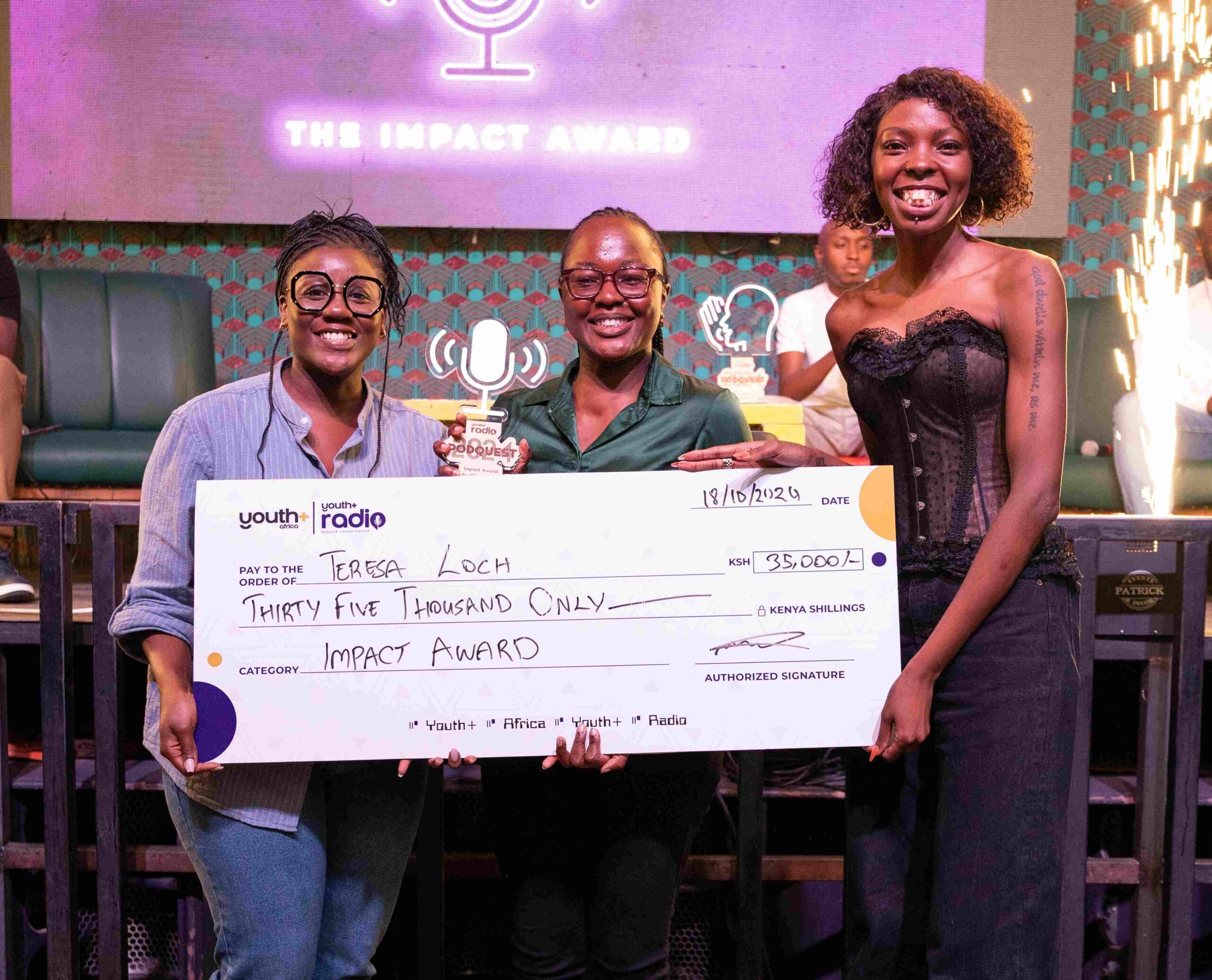 Mariah Mariah, Media personality and 1/3 at Mic Cheque podcast, Teresa Loch Impact Award winner, Adelle Onyango, Founder of the Legally Clueless podcast and media personality pose for a picture with dummy cheque at the Inaugural Youth+ Radio PodQuest 2024 Award Ceremony at Alchemist, Westlands.