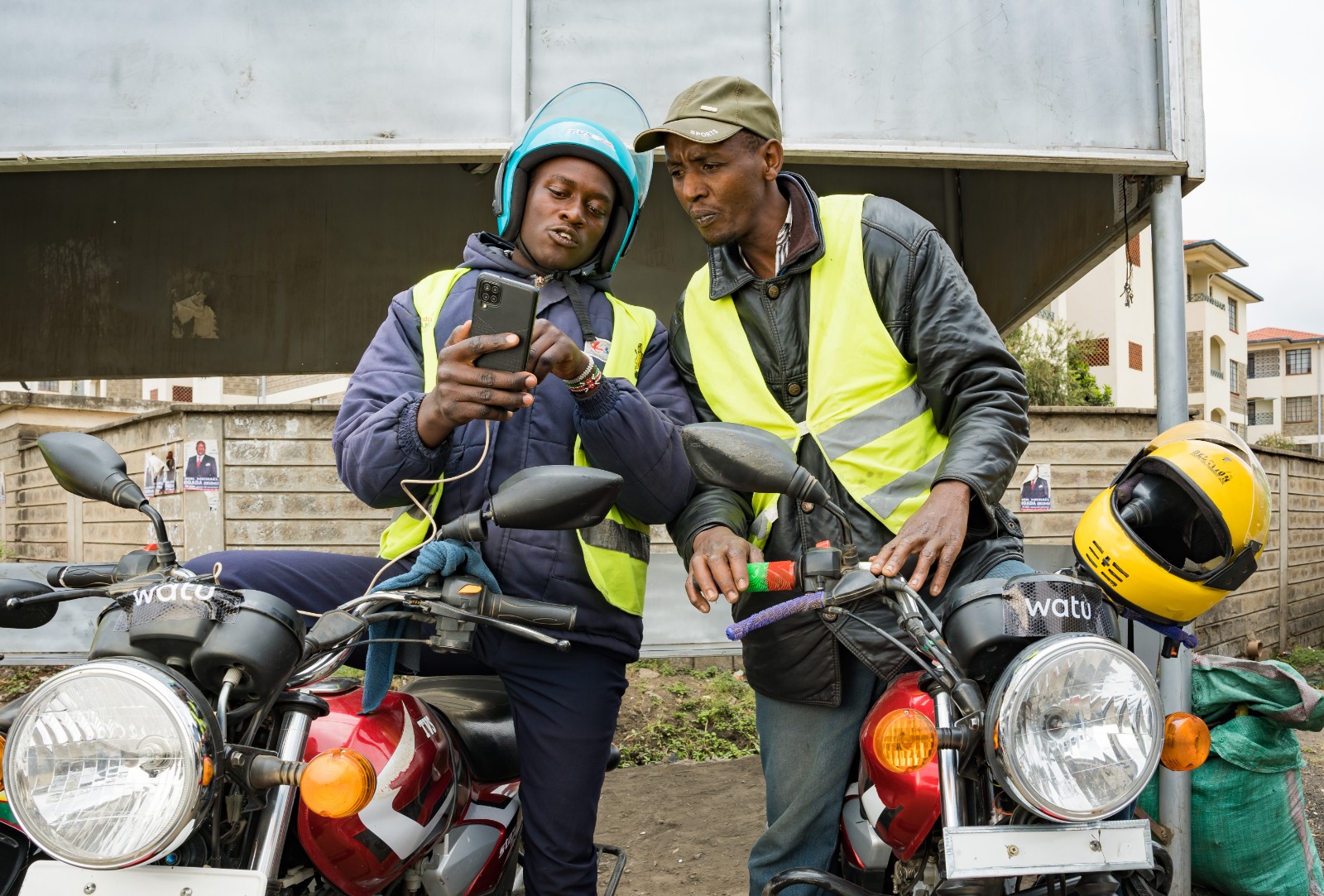 Boda Boda riders reviewing some operating features on a smartphone