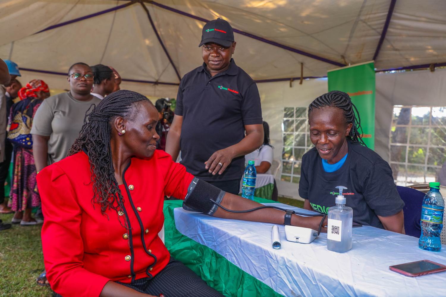 Gunilla Ouko (left), Regional Business lead, Greater Western Region, checking her blood pressure during a M-PESA Foundation medical camp in Vihiga County.