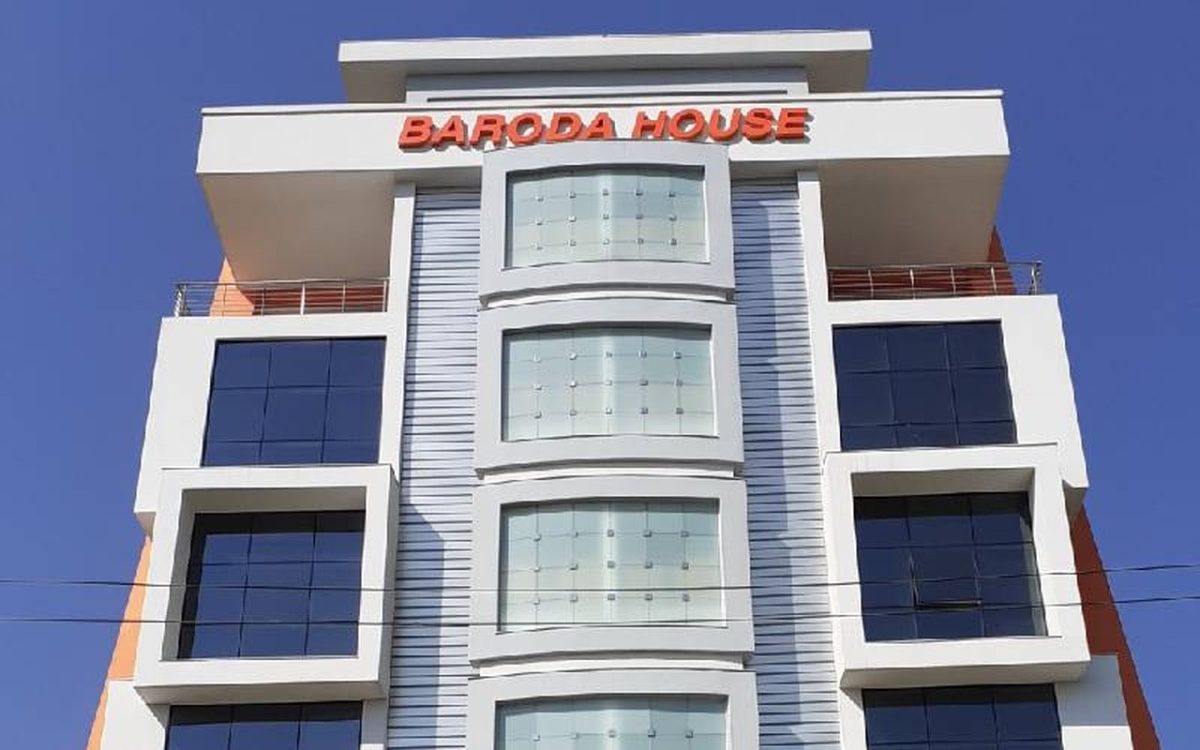 Baroda House, a white multi-storey office building with orange Baroda House lettering against a blue sky