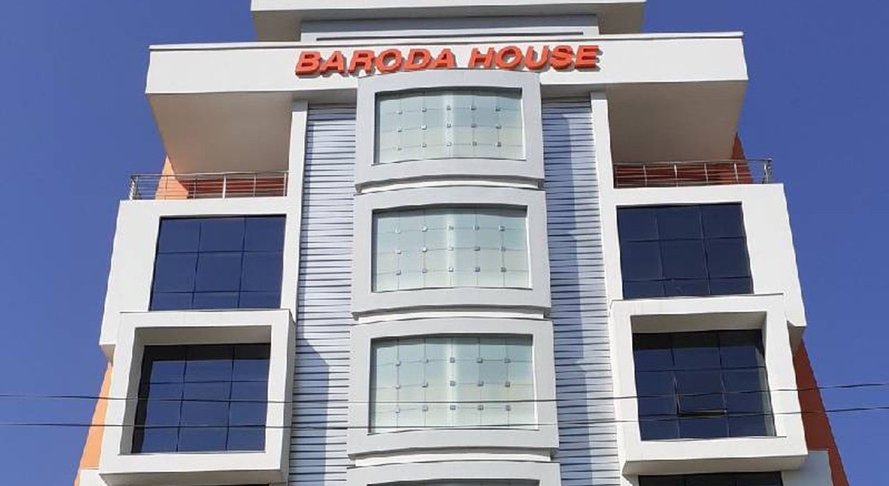 Baroda House, a white multi-storey office building with orange Baroda House lettering against a blue sky