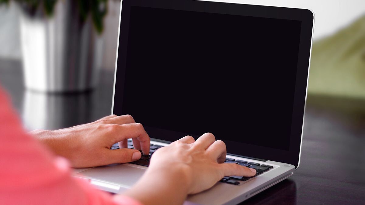 Hands typing on a laptop keyboard, the kind of setup used for online freelance work