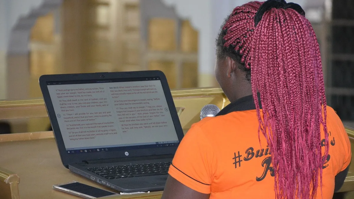 Young woman working on a laptop at a desk – illustrating capitation per learner kenya