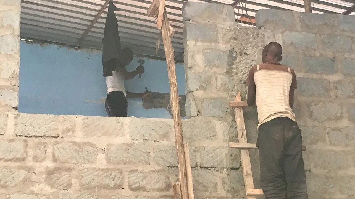 Workers building an office in Kenya – illustrating co op bank help