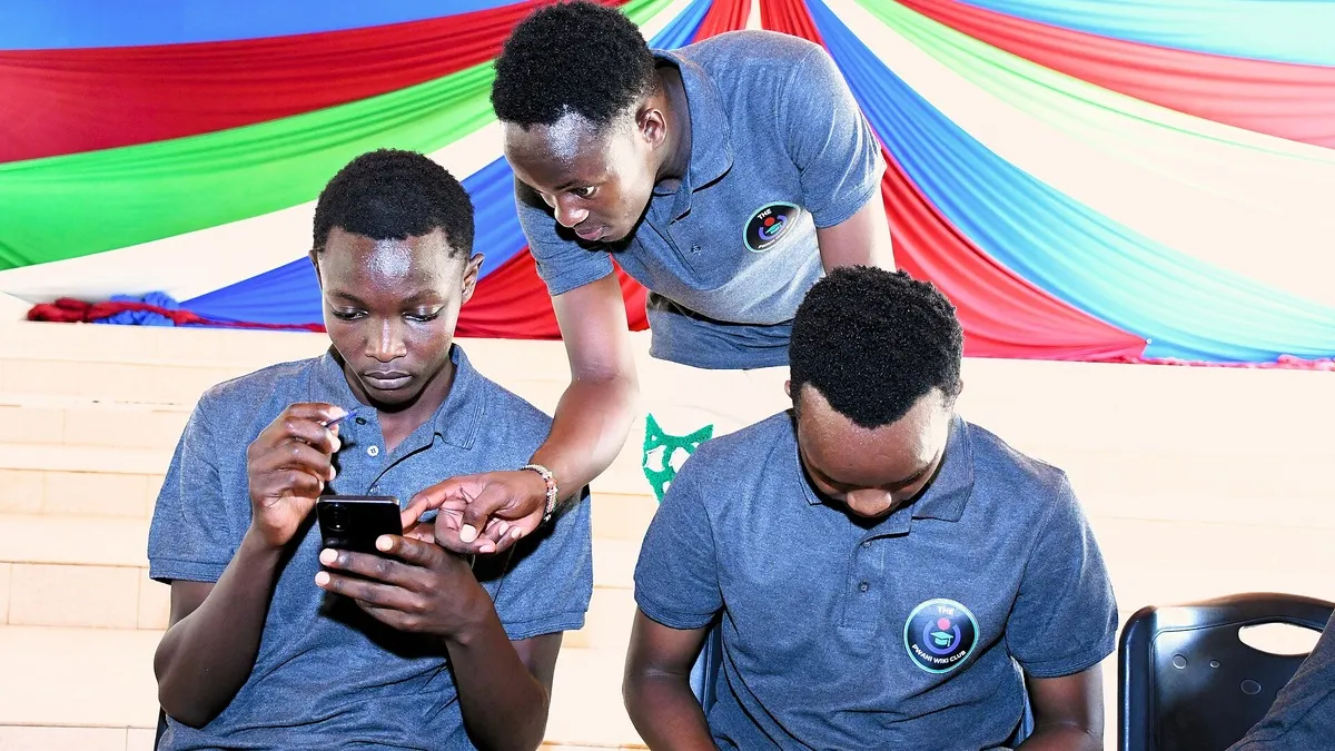 University students looking at a smartphone together – helb repayment crb