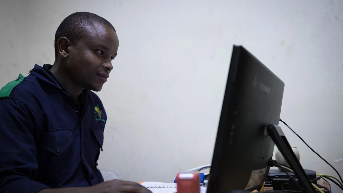 Kenyan office worker at a computer – How to Create an eCitizen Account in Kenya (2026)