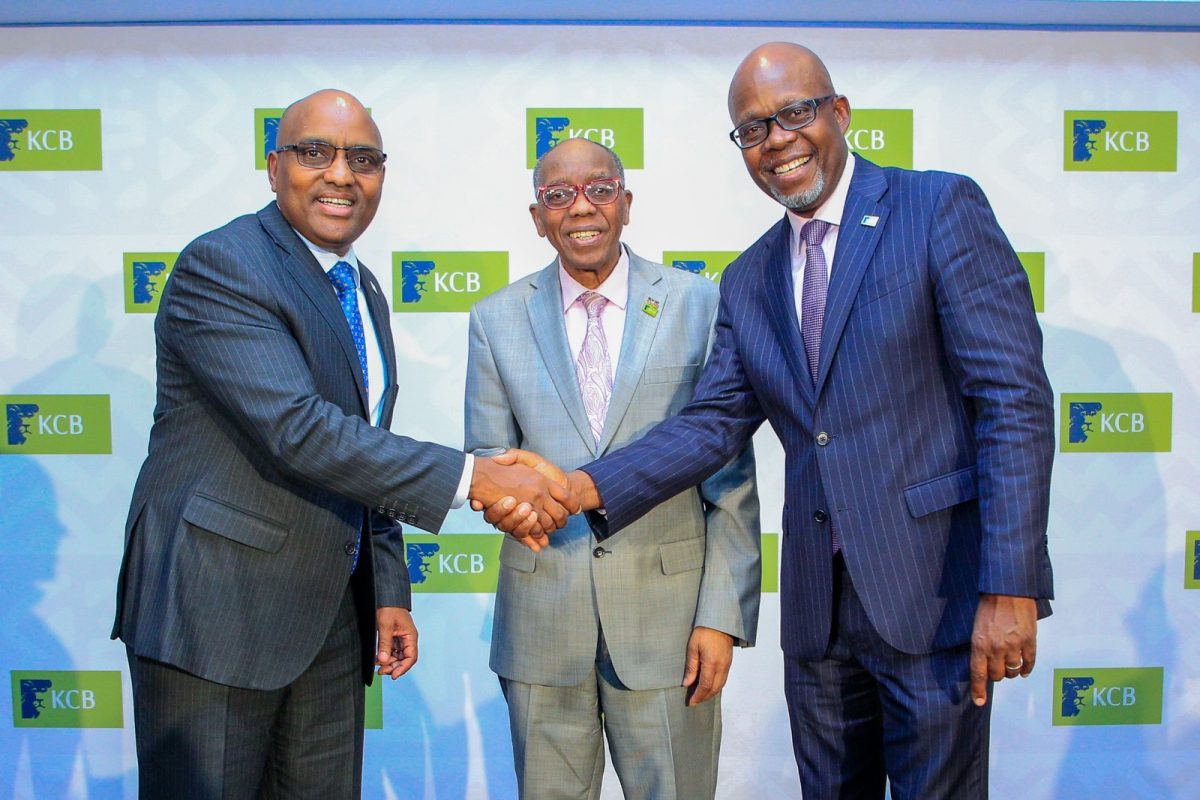 KCB Group executives shaking hands in front of a KCB-branded backdrop