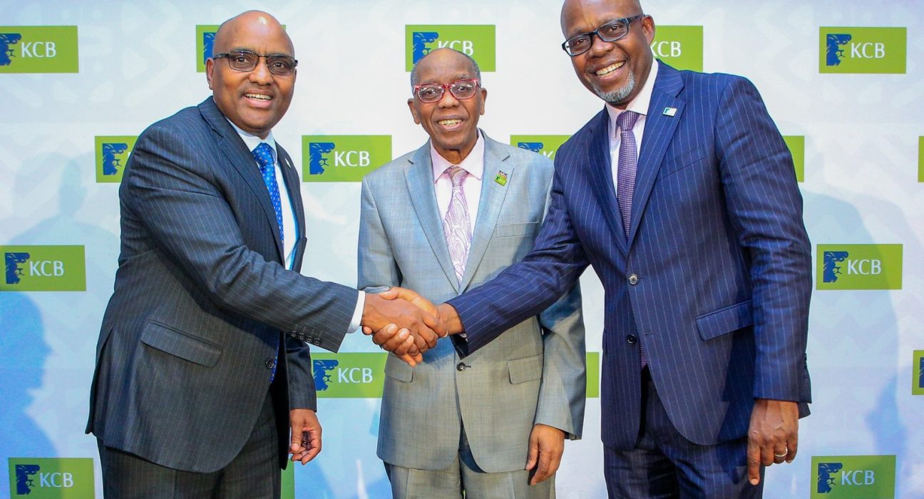 KCB Group executives shaking hands in front of a KCB-branded backdrop