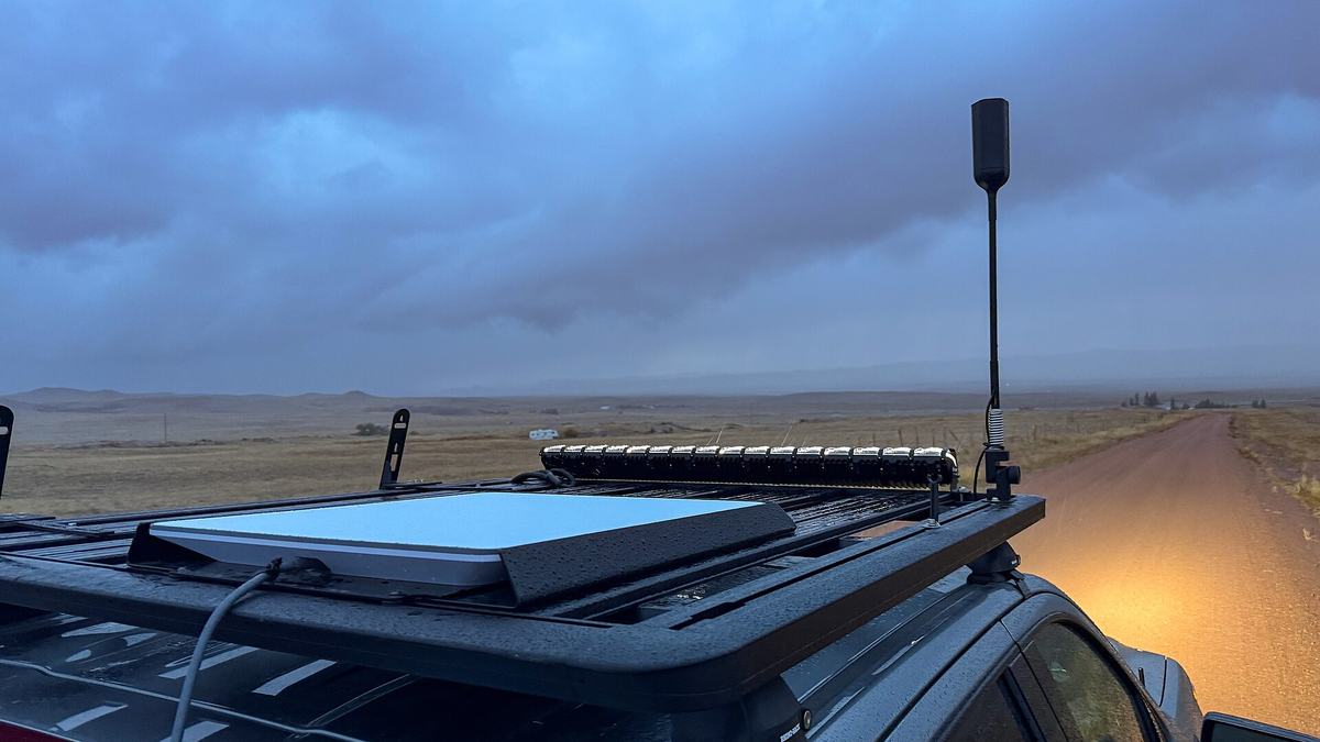 A flat Starlink satellite internet dish mounted on the roof of a vehicle