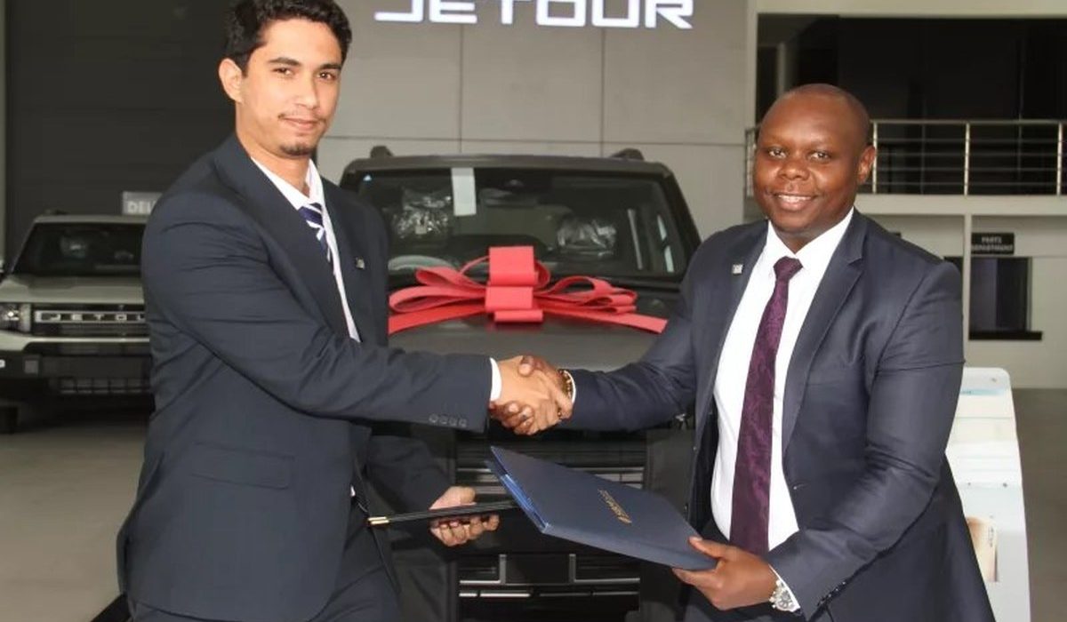 Global Motors Centre director Abdallah Zubedi and SBM Bank Kenya's Eric Wambua shake hands in front of a Jetour SUV at the Jetour showroom in Nairobi