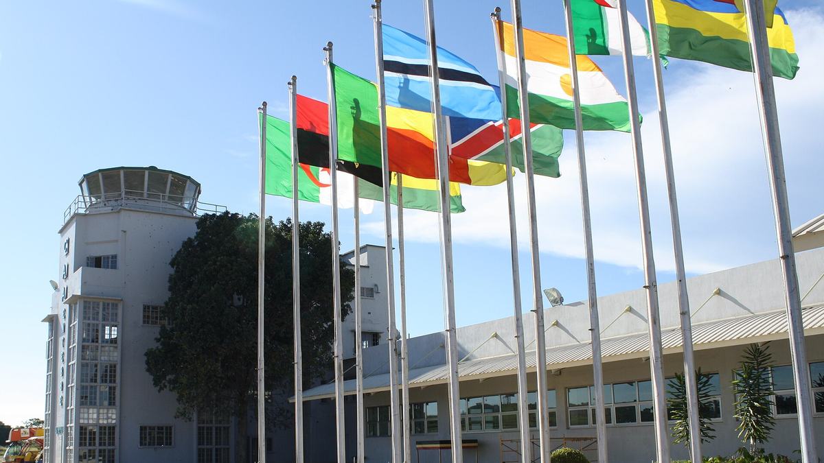 Entebbe International Airport control tower and terminal with a row of national flags in front